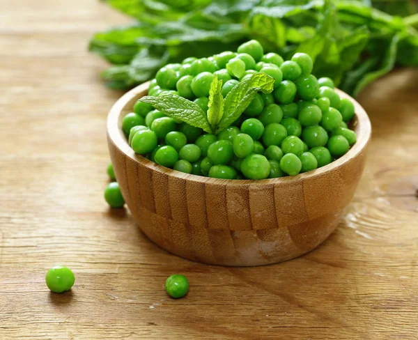 Frische grüne Erbsen in einer Holzschüssel — Stockfoto