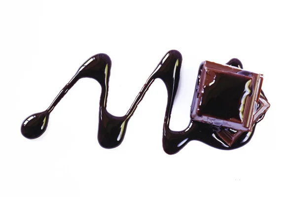 Pezzi di cioccolato fondente e sciroppo su sfondo bianco — Foto Stock