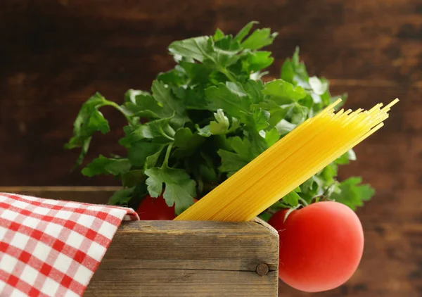 Traditional pasta spaghetti with tomatoes and herbs on a wooden table — Stock Photo, Image