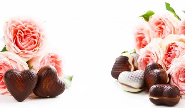 Fiori rosa e cuori di cioccolato caramelle. Regalo per la vacanza — Foto Stock