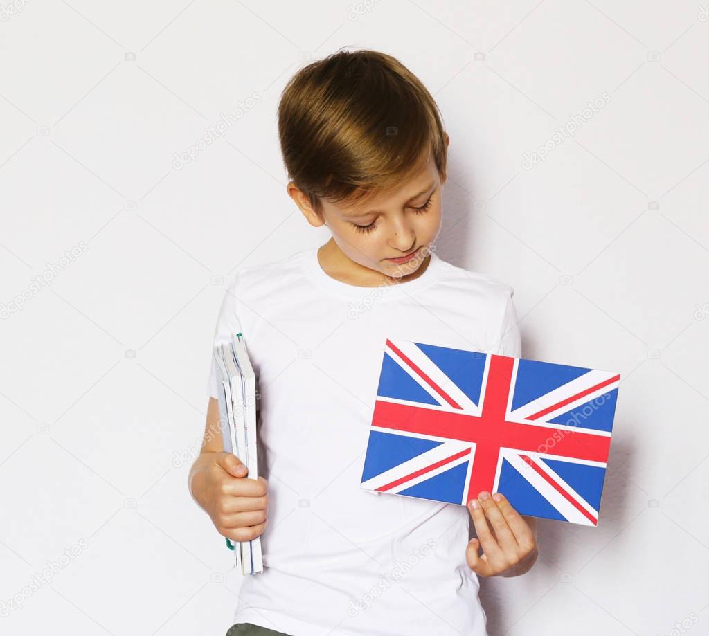 Cute blonde boy in casual clothes posing with british flag