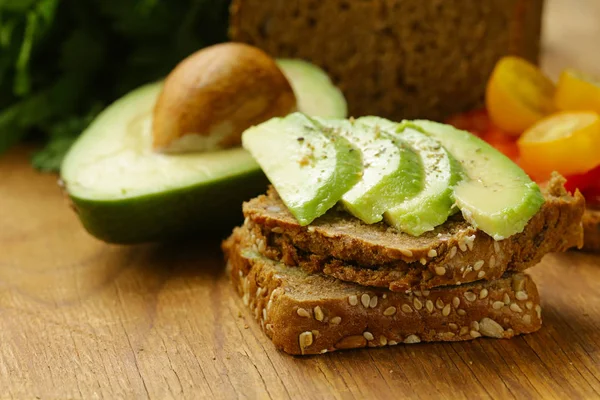 Sandwich with rye bread, avocado and tomatoes — Stock Photo, Image