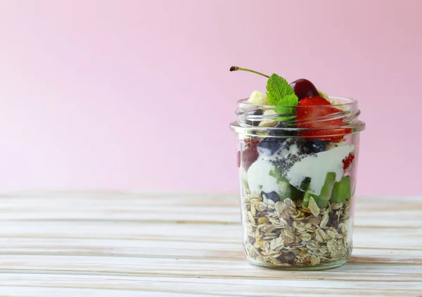 Breakfast homemade granola with berries and chia seeds in a glass jar — Stock Photo, Image