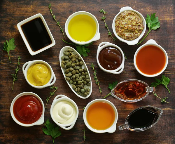 Різні види соусів і олій в мисках, вид зверху — стокове фото