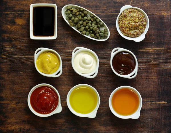 Different types of sauces and oils in bowls, top view — Stock Photo, Image