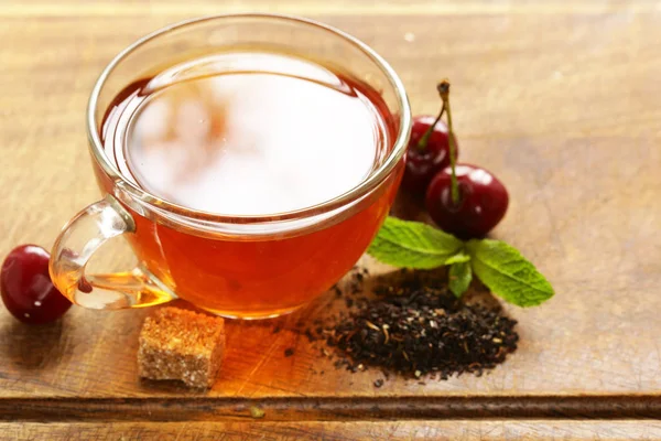 Фруктовый вишневый чай в чашке на столе — стоковое фото