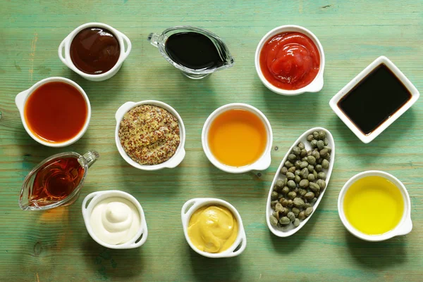 Różne rodzaje sosów i oleje w miskach, widok z góry — Zdjęcie stockowe