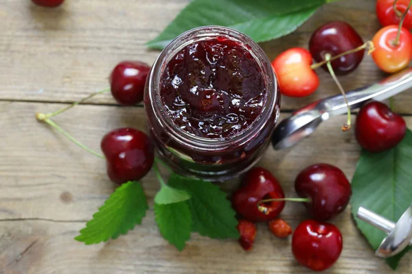 Biologische cherry jam met verse bessen op tafel — Stockfoto