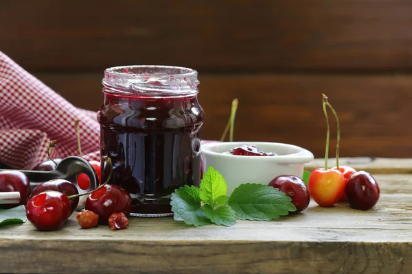 Mermelada de cereza ecológica con bayas frescas en la mesa —  Fotos de Stock