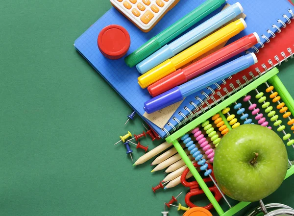 Schulkanzlei und Apfel auf grünem Hintergrund — Stockfoto