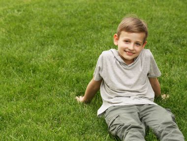 Genç yakışıklı yeşil çimenlerin üzerinde - yaz saati, piknik dinleniyor.