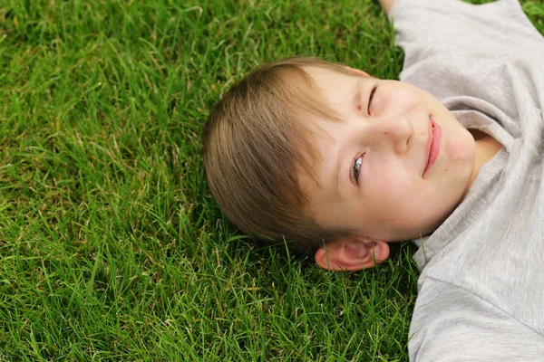Lindo joven descansando sobre la hierba verde - hora de verano, picnic — Foto de Stock