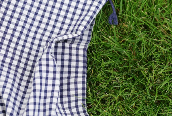 Background for a picnic - plaid on green grass — Stock Photo, Image