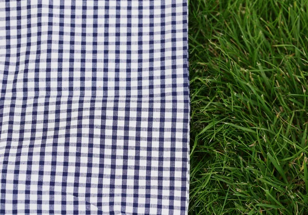 Background for a picnic - plaid on green grass — Stock Photo, Image