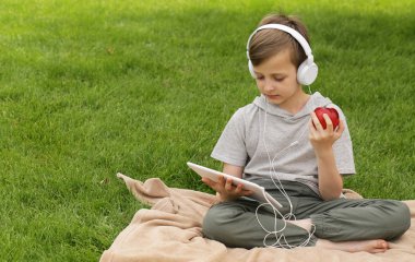 Genç yakışıklı yeşil çimenlerin üzerinde - yaz saati, piknik dinleniyor.