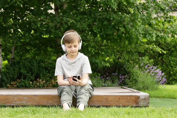 Netter kleiner Junge, der sich auf dem grünen Gras ausruht - Sommerzeit, Picknick — Stockfoto