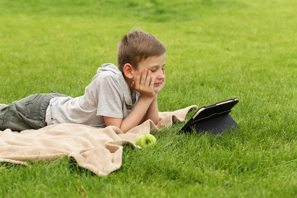 Aranyos szőke fiú, olvasson egy könyvet a park szabadban — Stock Fotó