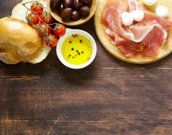 Comida italiana - azeitonas, presunto de parma, tomates, queijo mussarela — Fotografia de Stock