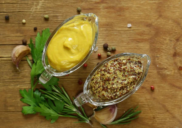 Natuurlijke mosterd, kruiden en saus op een houten tafel — Stockfoto