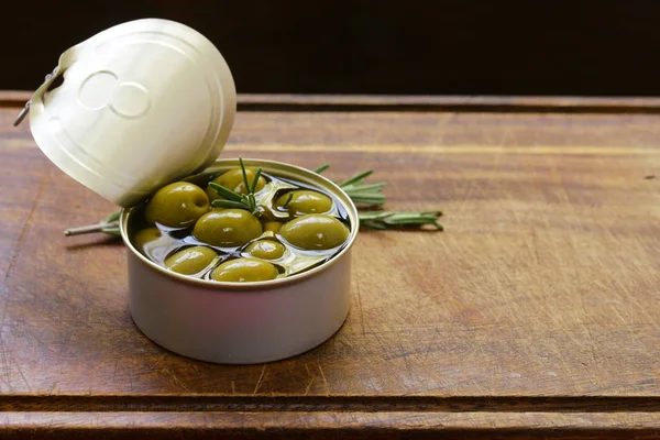 Organic canned green olives on a wooden table — Stock Photo, Image