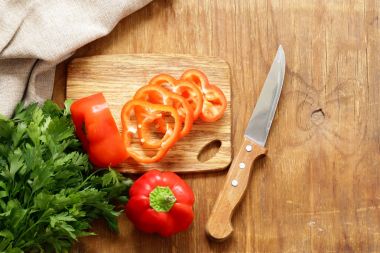 Ahşap masa üzerinde organik gıda tatlı kırmızı biber dilimlenmiş