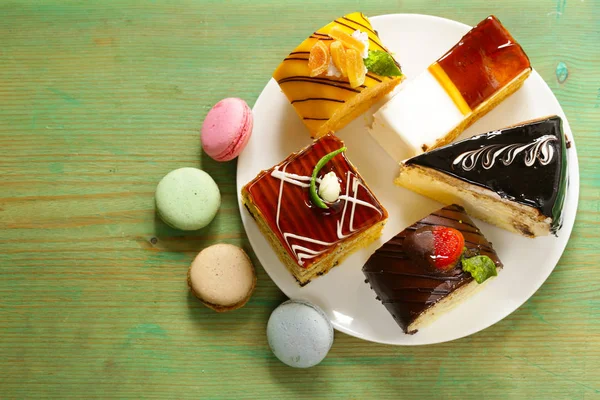 Vegyes mini sütemények édes desszert, csokoládé és gyümölcsök — Stock Fotó