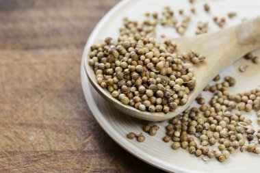 Bir tabloda bir tahta kaşık baharat kişniş