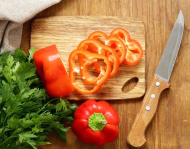 Ahşap masa üzerinde organik gıda tatlı kırmızı biber dilimlenmiş