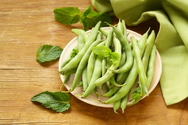 Färska gröna ärtor på ett träbord, ekologisk mat — Stockfoto