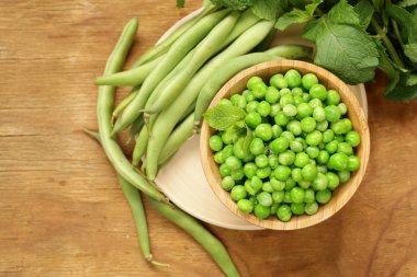 Ahşap bir masa, organik gıda üzerinde taze yeşil bezelye