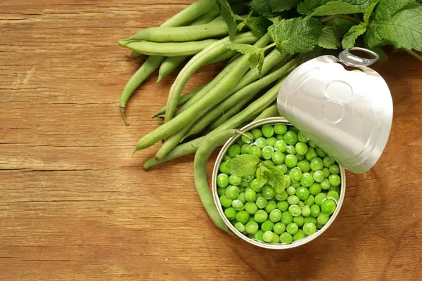 Frische grüne Erbsen auf einem Holztisch, Bio-Lebensmittel — Stockfoto