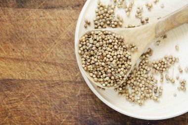 Bir tabloda bir tahta kaşık baharat kişniş