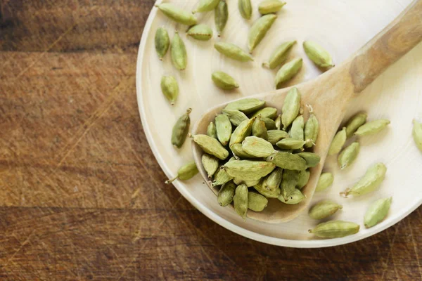 Spices cardamom in a wooden spoon on a table — Stock Photo, Image