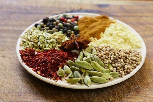 Various spices (cardamom, paprika, coriander, fennel) on a wooden background — Stock Photo, Image