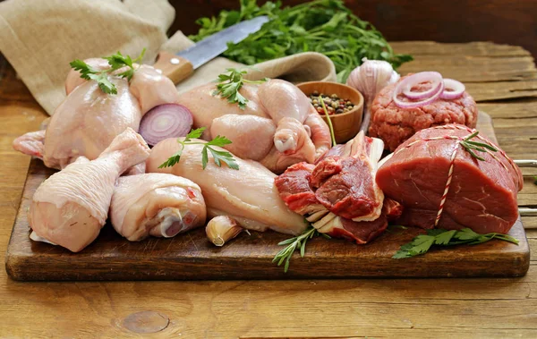 Assortimento di carne cruda - manzo, agnello, pollo su tavola di legno — Foto Stock