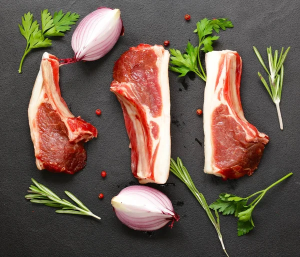 Rått kött, lamm revben på svart bakgrund — Stockfoto