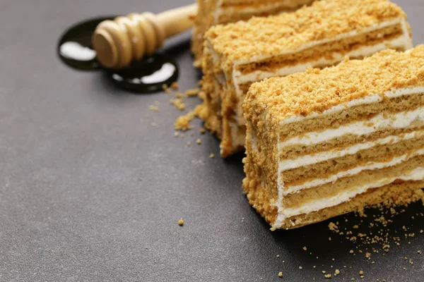 Gâteau au miel avec crème au beurre sur une planche de pierre — Photo