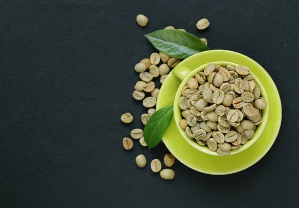 Grãos de café verdes orgânicos naturais em um fundo preto — Fotografia de Stock