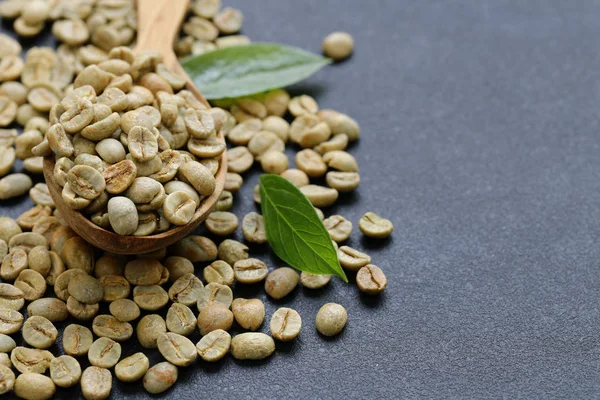 Grãos de café verdes orgânicos naturais em um fundo preto — Fotografia de Stock