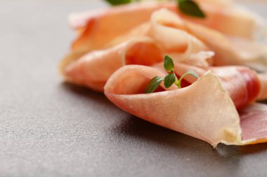 Parma jambonu ince dilimler siyah bir taş üzerinde