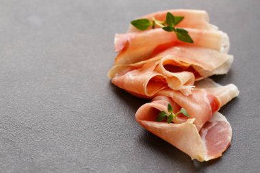Parma jambonu ince dilimler siyah bir taş üzerinde