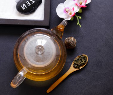 Bir çaydanlık kiraz çiçekleri bir dalı ile yeşil çay