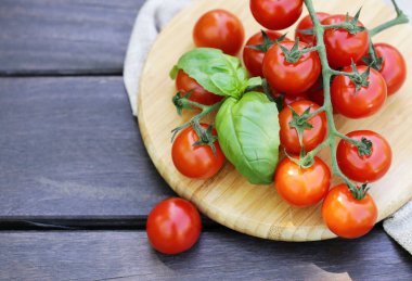 Tahta bir masada taze domates ve fesleğen.