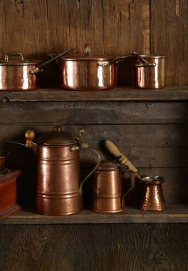 Ahşap arka planda bakır kaplar, tencereler, kepçe ve tava