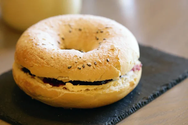 breakfast bagel with toppings and coffee on the table