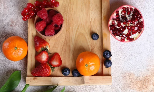 Früchte Und Beeren Auf Einem Holztablett — Stockfoto