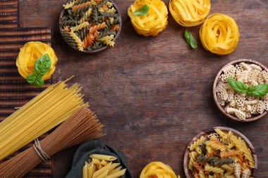 Tahta arka planda doğal organik makarna çeşitleri.