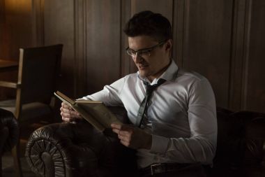 Adam onun ofisinde bir kitap okuyor