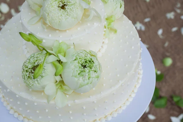 Bröllopstårta med blommor på toppen — Stockfoto