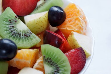 Kivi, portakal, erik ve diğer meyvelerden taze salata yakın. Sağlıklı yaşam tarzı.